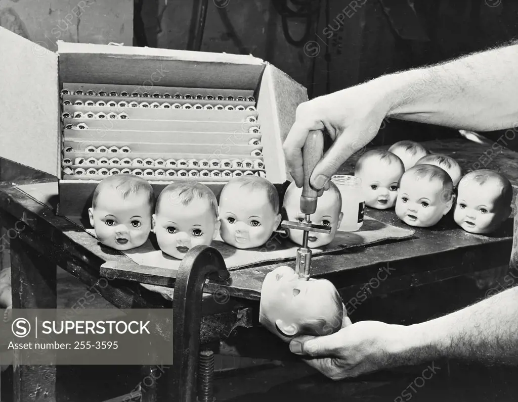 Vintage photograph. Doll manufacturing - cutting eyes on doll head