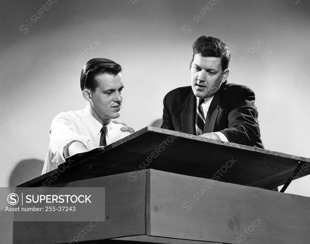 Stock Photo: 255-37243 Low angle view of two architects discussing blueprint