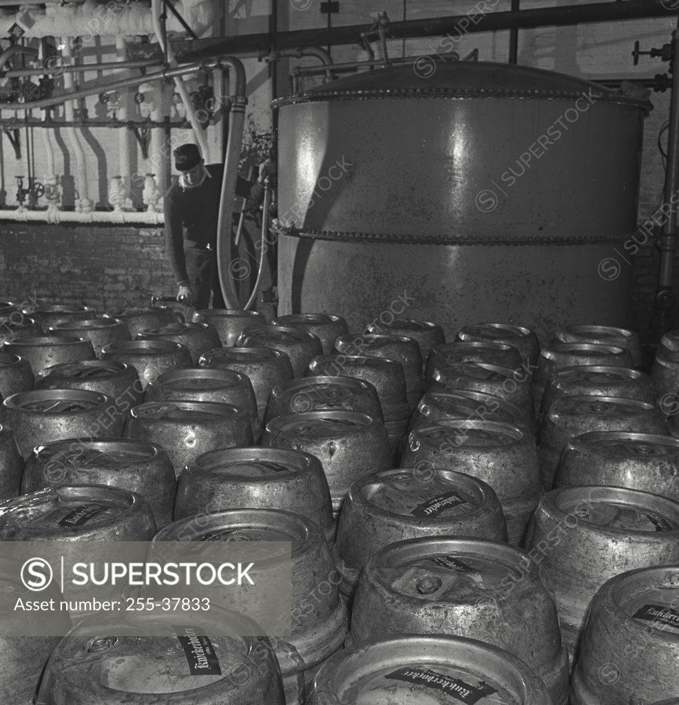 Stock Photo: 255-37833 Male worker checking barrels in a food processing plant, Rupperts Brewery, New York City, New York State, USA