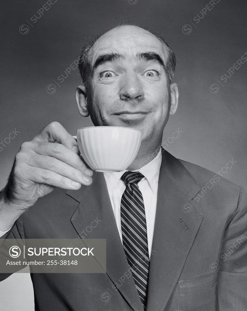 Stock Photo: 255-38148 Studio portrait of mid adult man holding tea cup