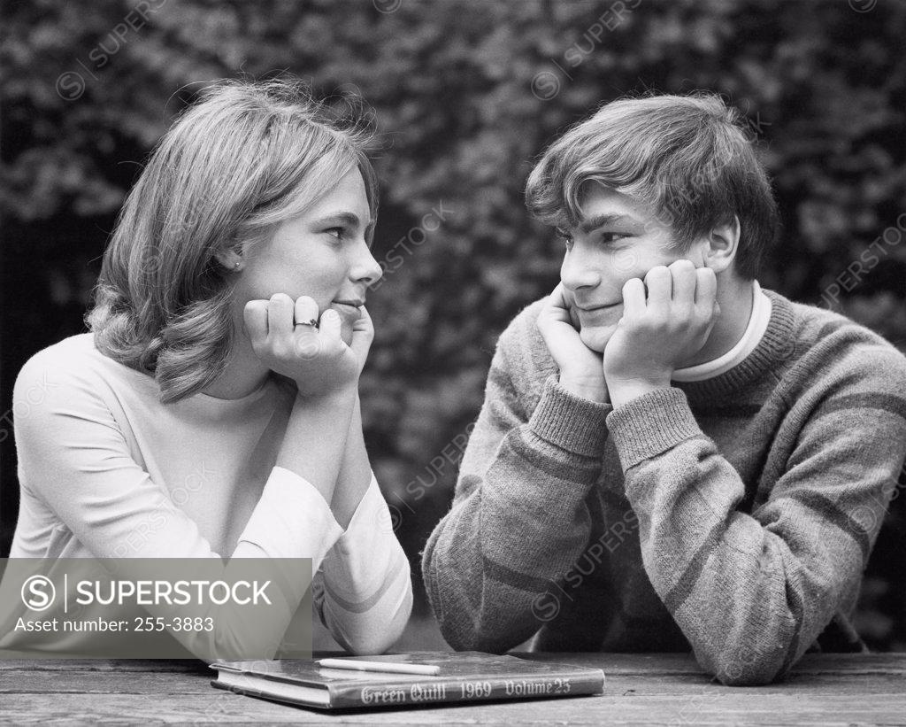 Stock Photo: 255-3883 Close-up of a teenage couple sitting at a table and looking at each other