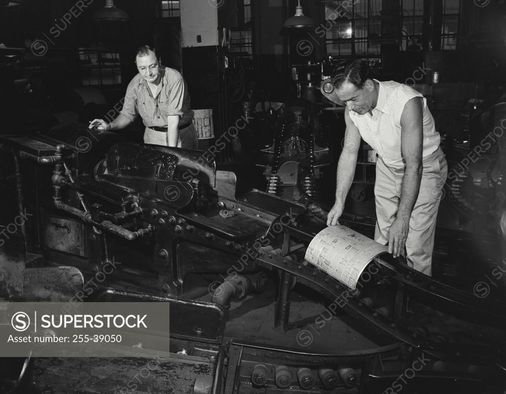 Stock Photo: 255-39050 Two male workers working in a printing press