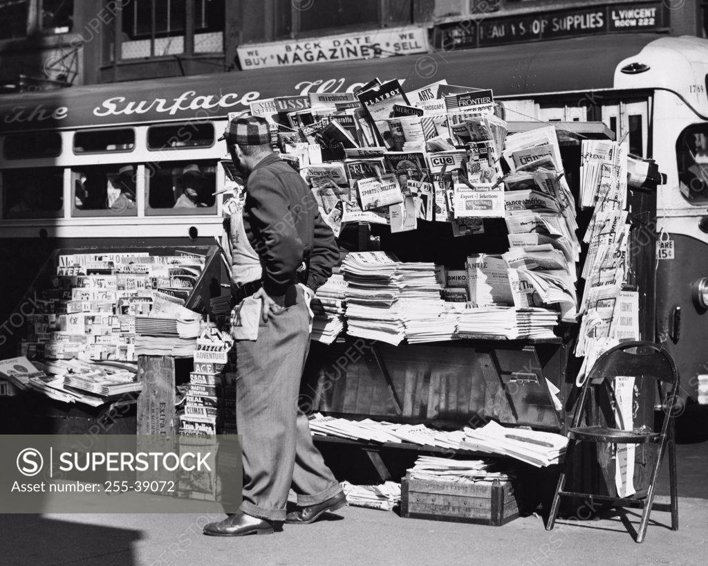 Stock Photo: 255-39072 Side profile of a vendor standing in front of his news stand, New York City, USA
