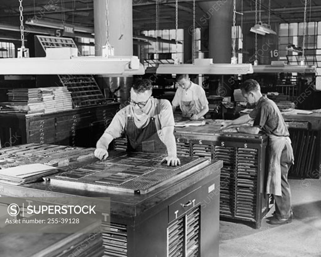 Stock Photo: 255-39128 Three mature men working in a factory
