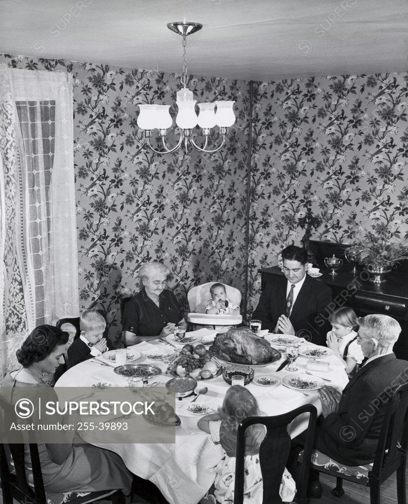 Stock Photo: 255-39893 High angle view of a family praying at a dining table on Thanksgiving Day