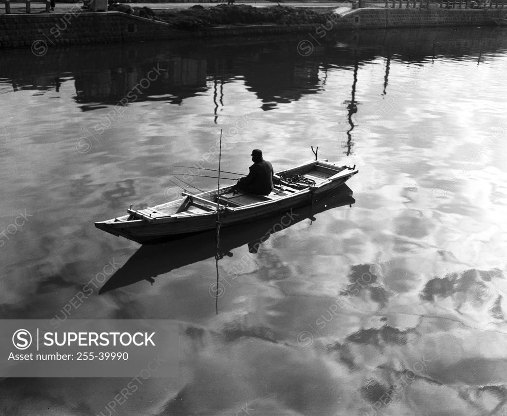 Stock Photo: 255-39990 High angle view of a man sitting on a rowboat and fishing in a lake