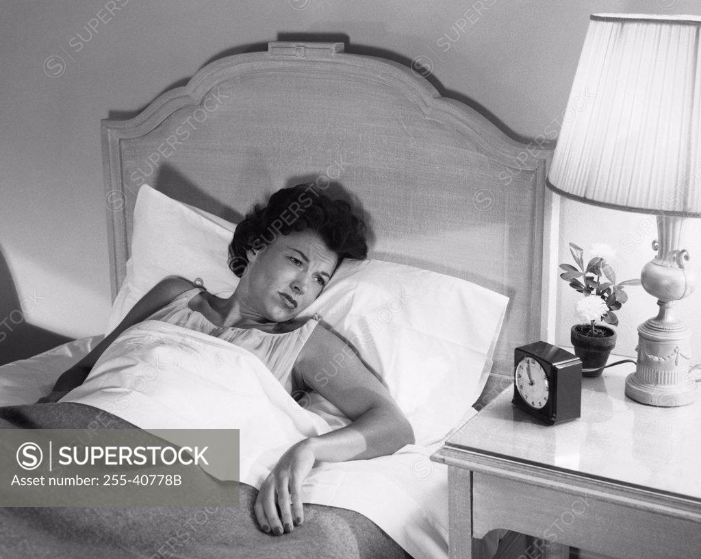 Stock Photo: 255-40778B High angle view of a young woman lying in the bed