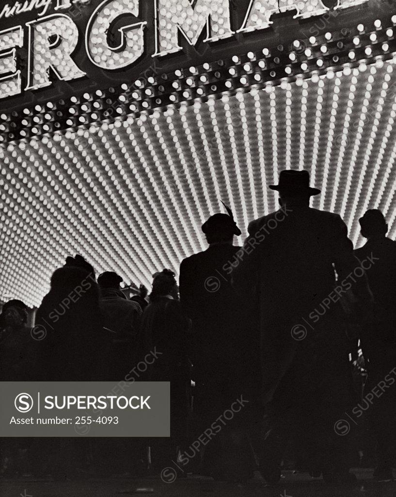 Stock Photo: 255-4093 Silhouette of a group people standing outside a theater