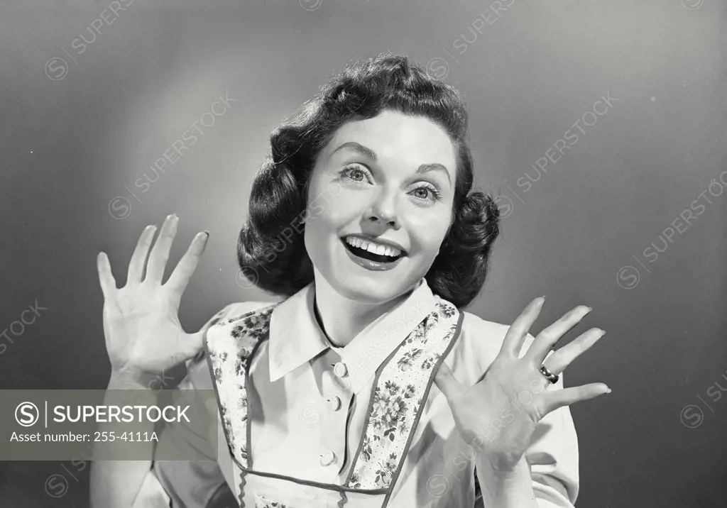 Portrait of young woman smiling with hands raised