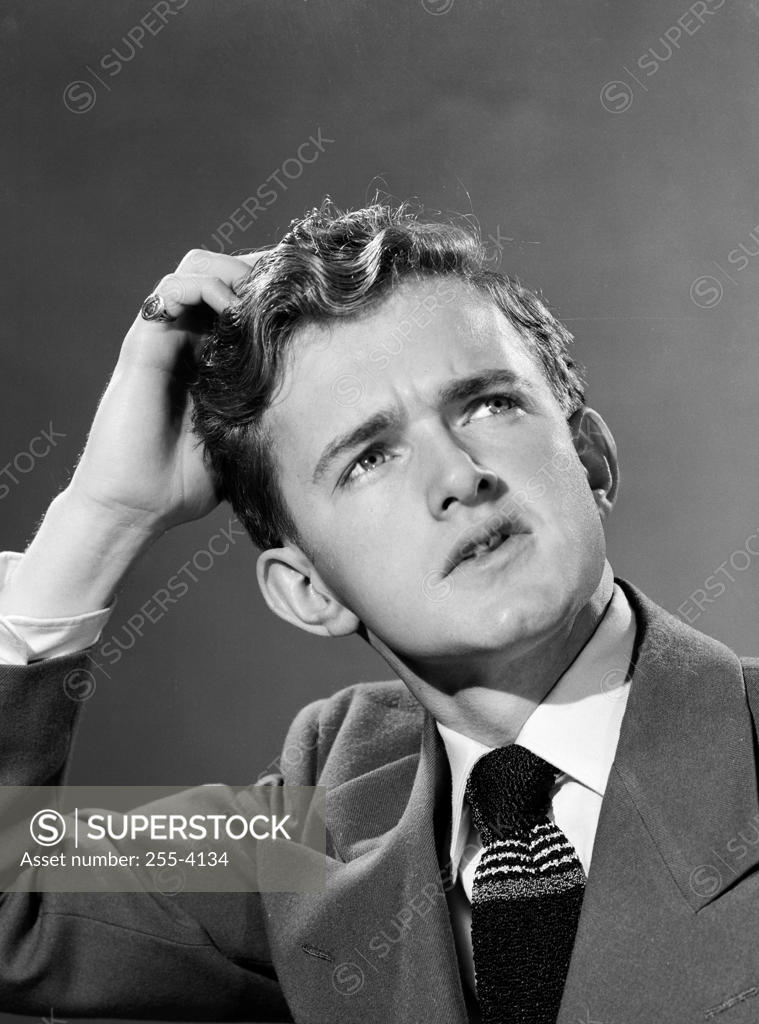 Stock Photo: 255-4134 Teenage boy scratching his head