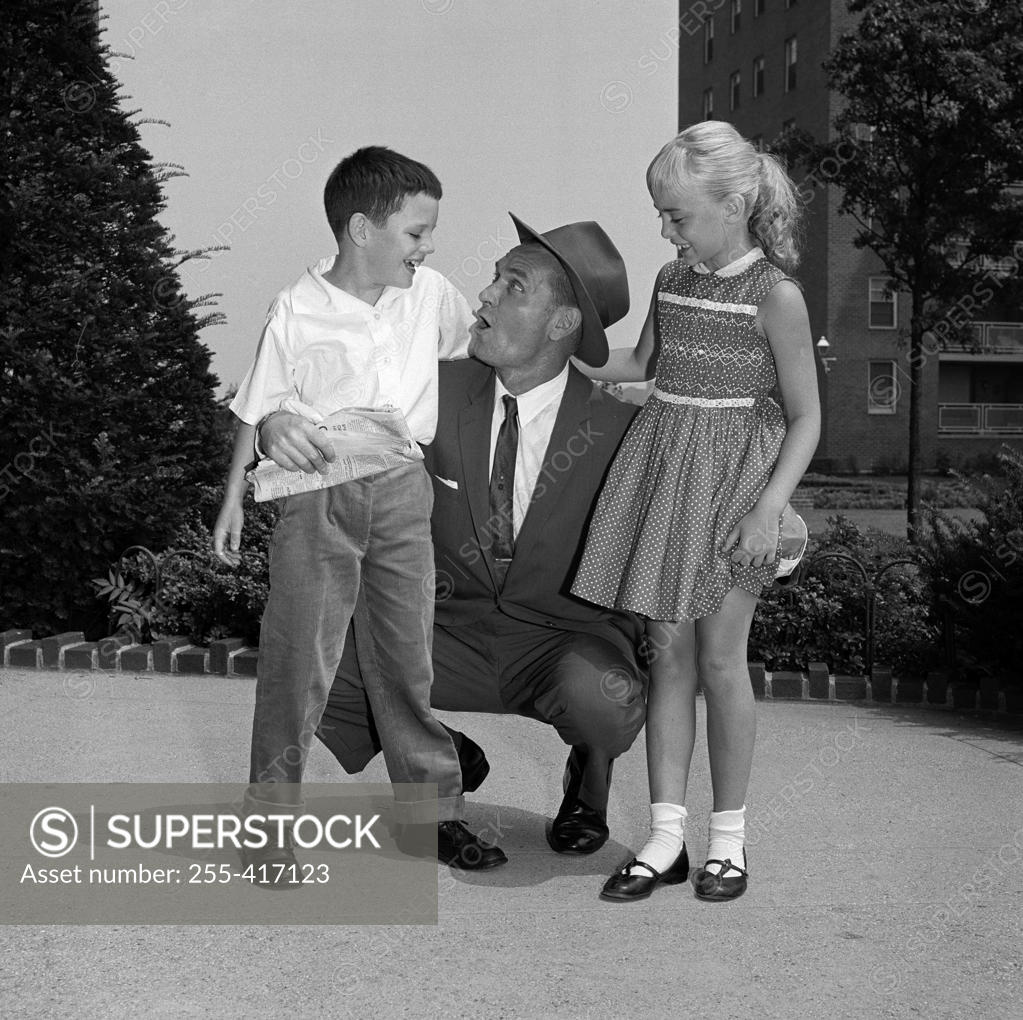 Stock Photo: 255-417123 Grandfather talking to grandson and granddaughter