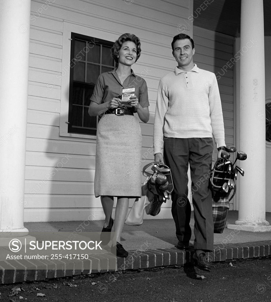 Stock Photo: 255-417150 Mid adult couple leaving for golf session