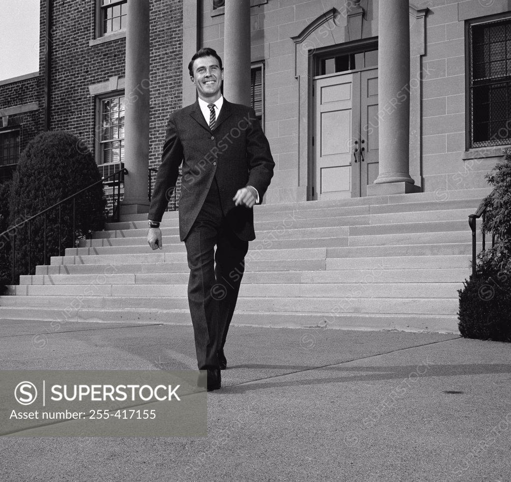 Stock Photo: 255-417155 Businessman walking from courthouse