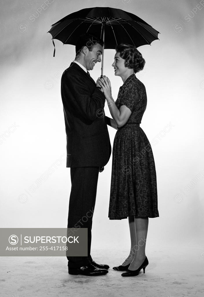 Stock Photo: 255-417158 Businessman and woman standing under umbrella