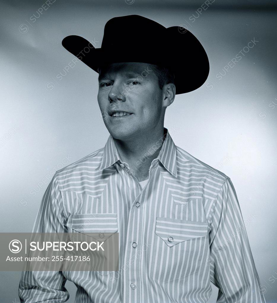 Stock Photo: 255-417186 Studio portrait of man wearing cowboy hat