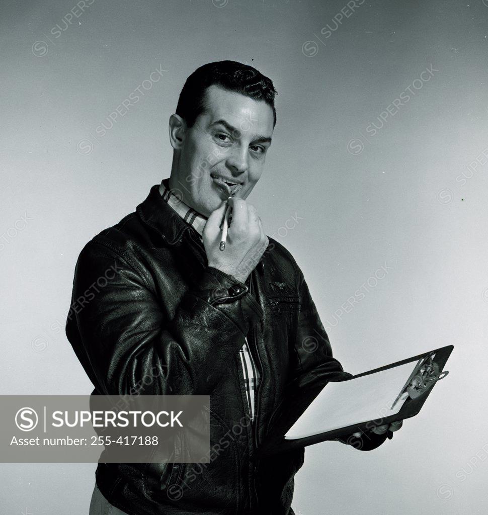 Stock Photo: 255-417188 Studio portrait of man holding clipboard and pen