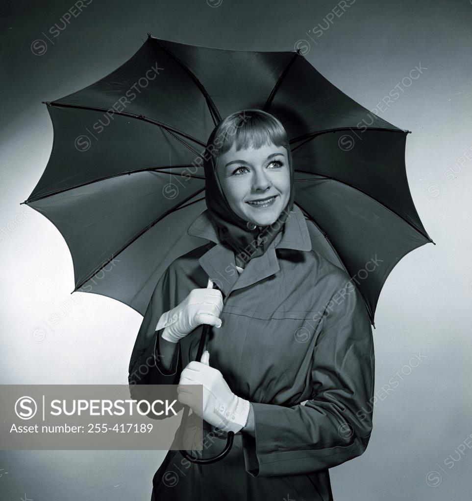 Stock Photo: 255-417189 Studio portrait of smiling woman with umbrella