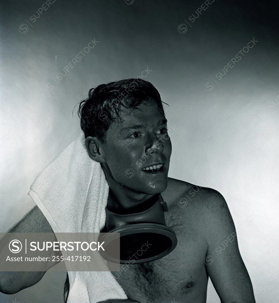 Stock Photo: 255-417192 Studio shot of man with gas mask drying hair with towel