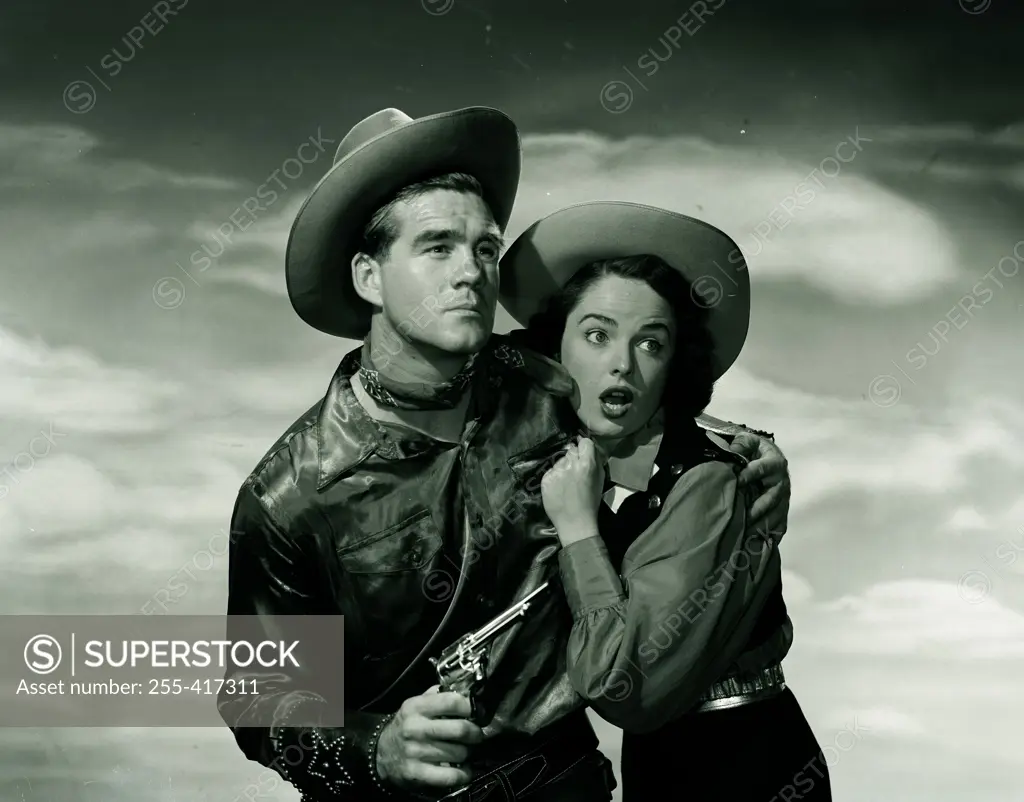 Cowboy with gun, protecting cowgirl
