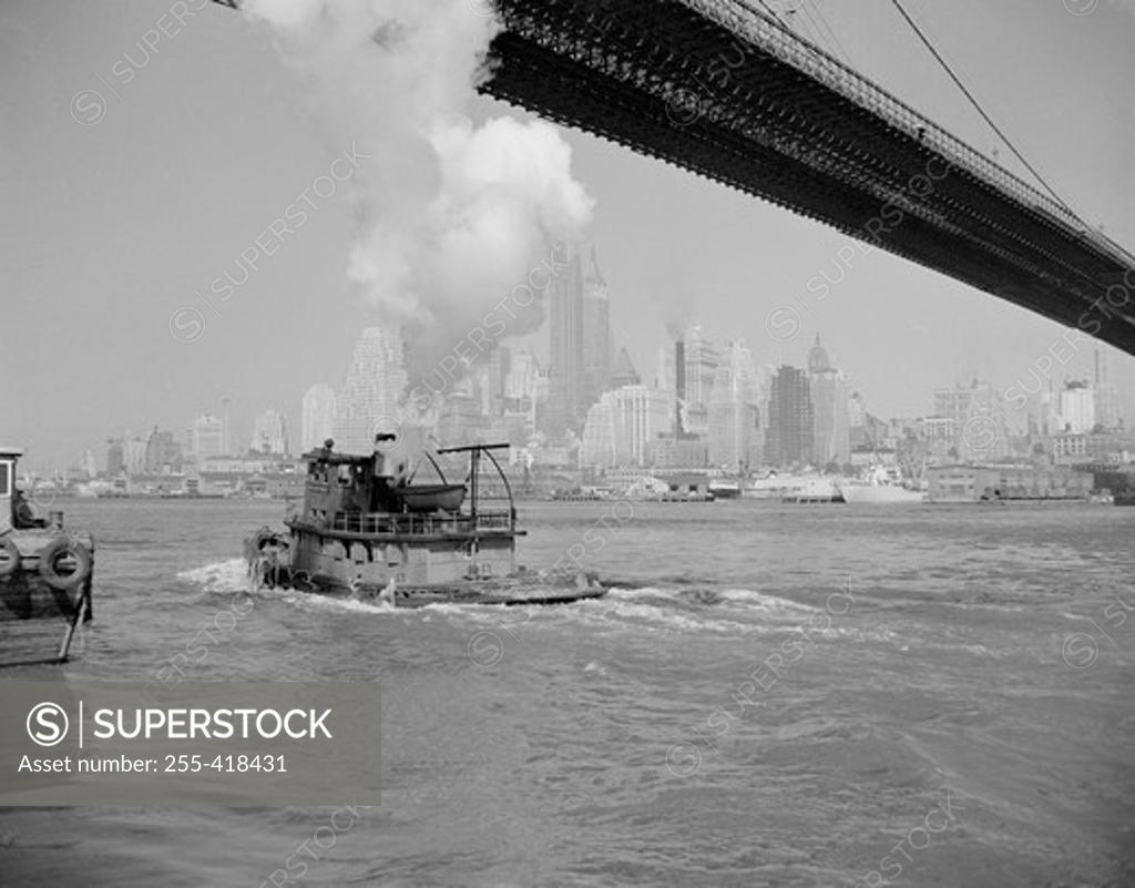 Stock Photo: 255-418431 USA, new York State, New York City, Manhattan, Steamboat floating under bridge, skyline in the background