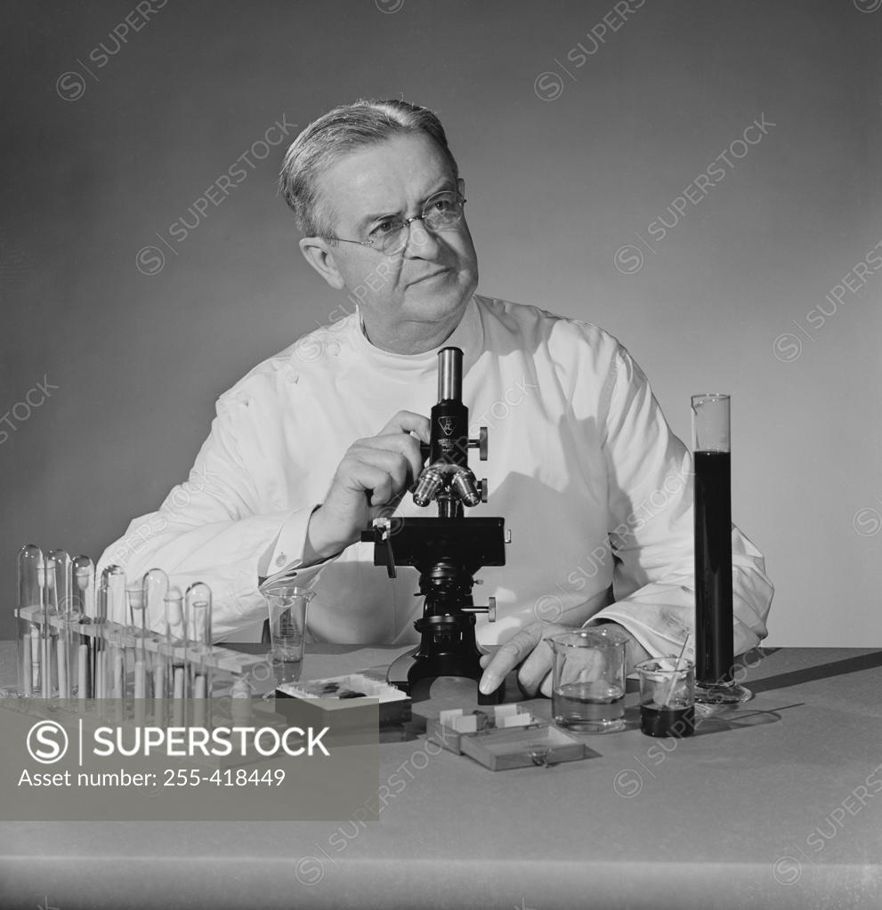 Stock Photo: 255-418449 Studio shot of scientist with microscope and test tubes
