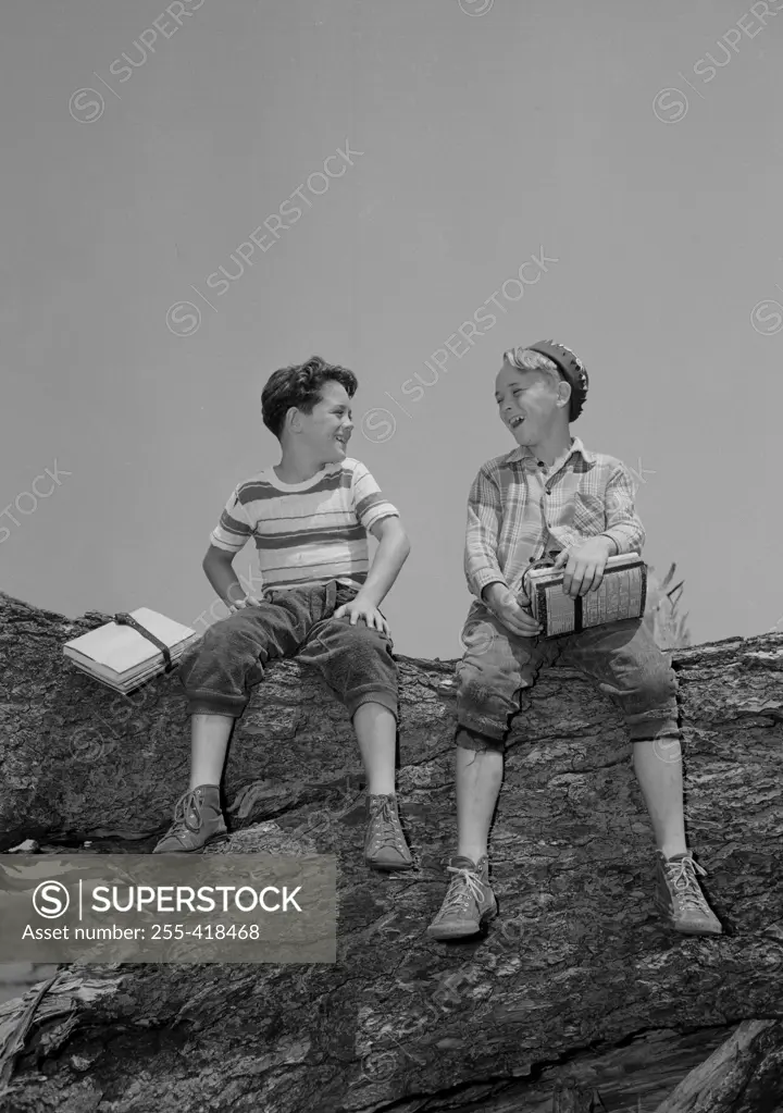 Two boys sitting on rock