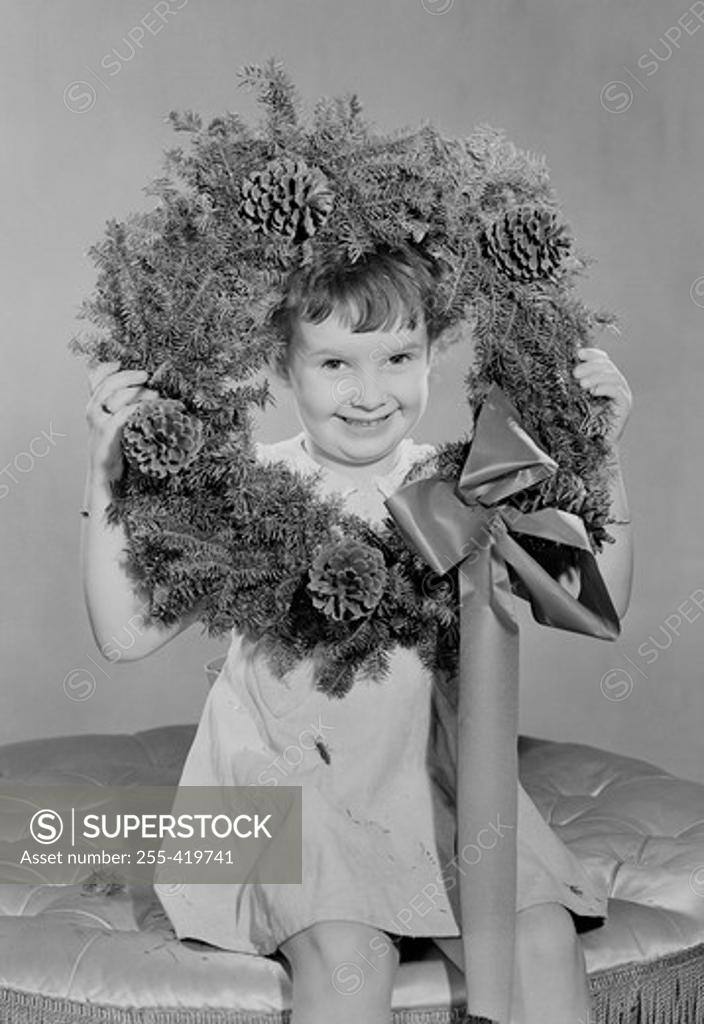 Stock Photo: 255-419741 Portrait of small girl holding Christmas wreath