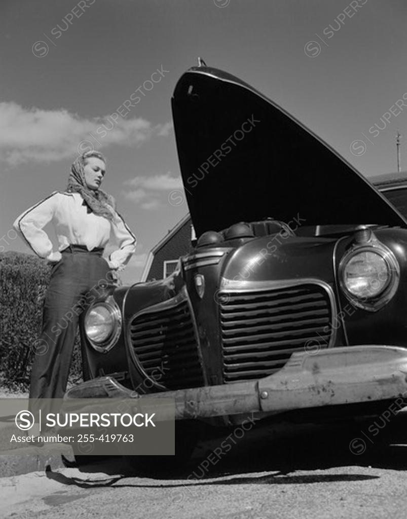 Stock Photo: 255-419763 Woman standing by car with open hood