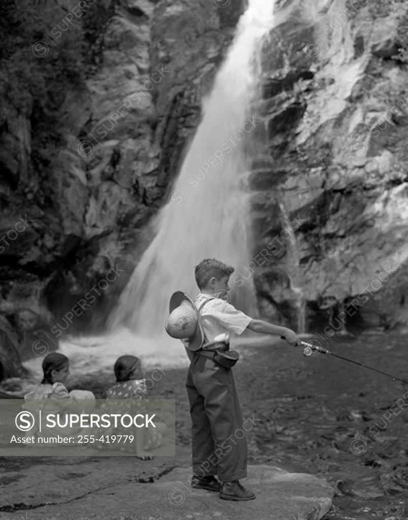 Stock Photo: 255-419779 Boy fishing and girls sitting by waterfall