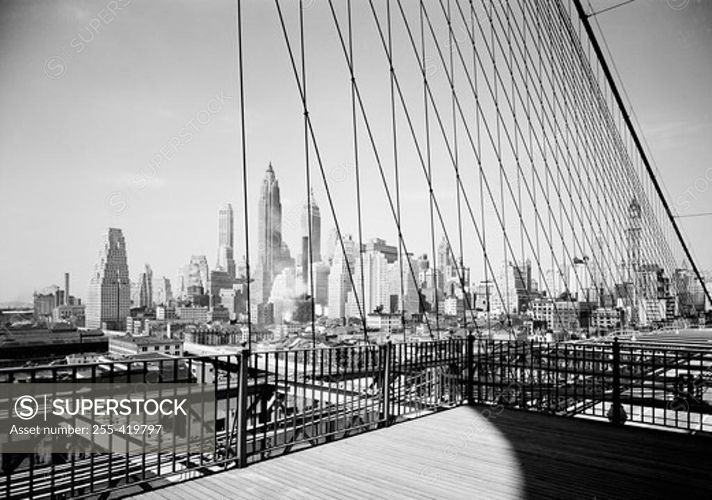 Stock Photo: 255-419797 USA, New York State, New York City, Lower Manhattan skyline as seen through cables of the Brooklyn Bridge