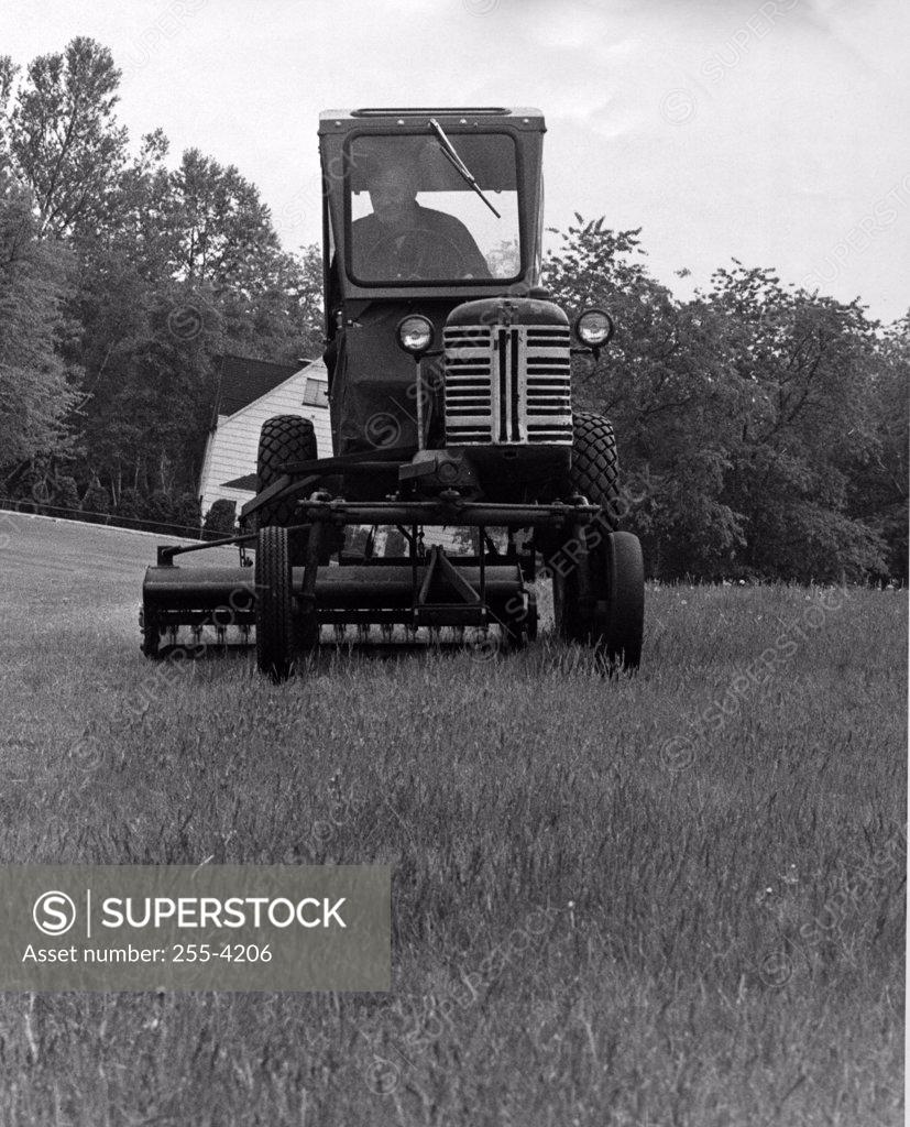 Stock Photo: 255-4206 Farmer driving a tractor in a field