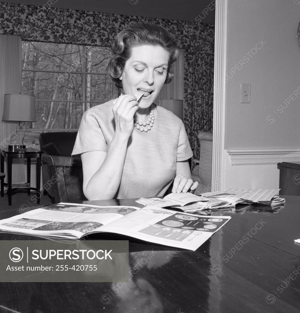 Stock Photo: 255-420755 Mid adult woman reading magazine at home