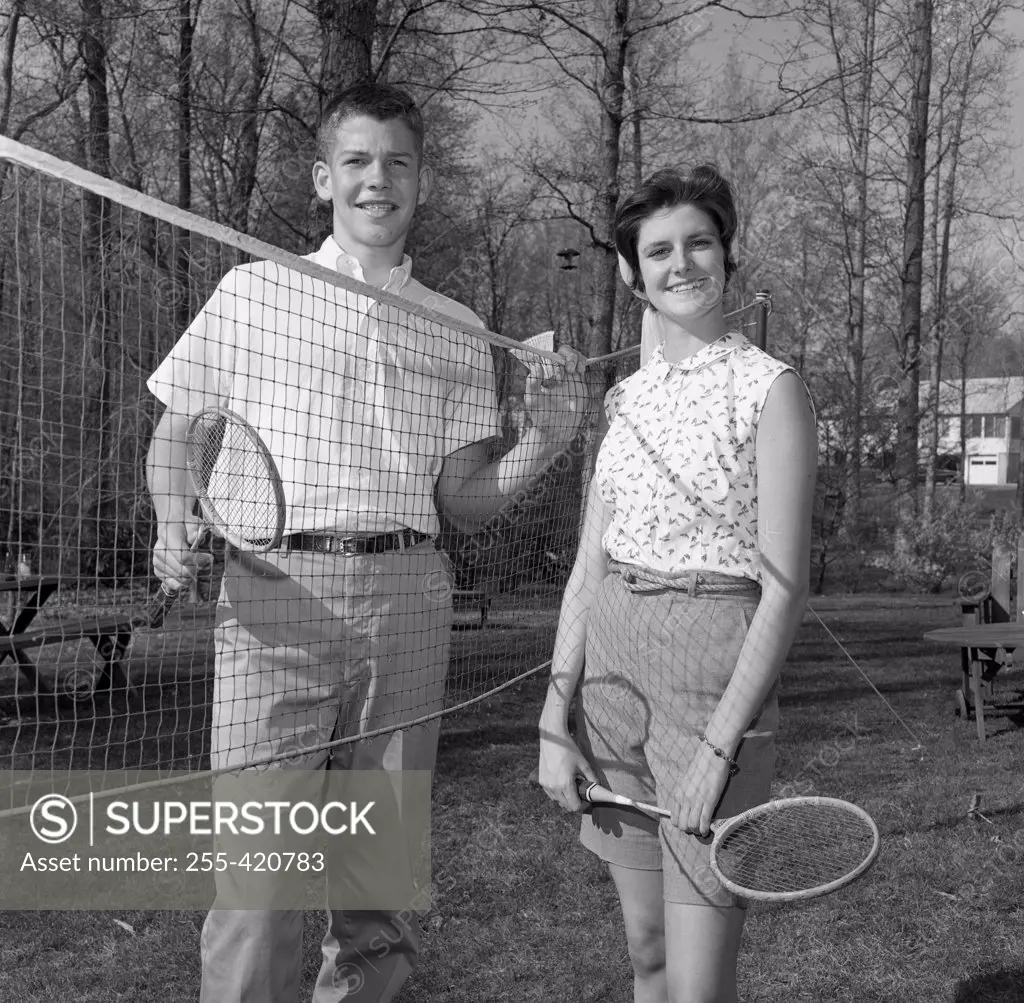 Young woman and young man playing badminton