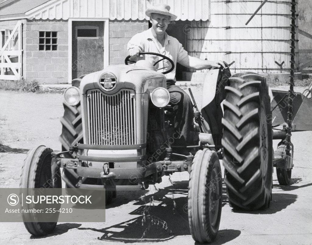 Stock Photo: 255-4210 Portrait of a mid adult man sitting on a tractor