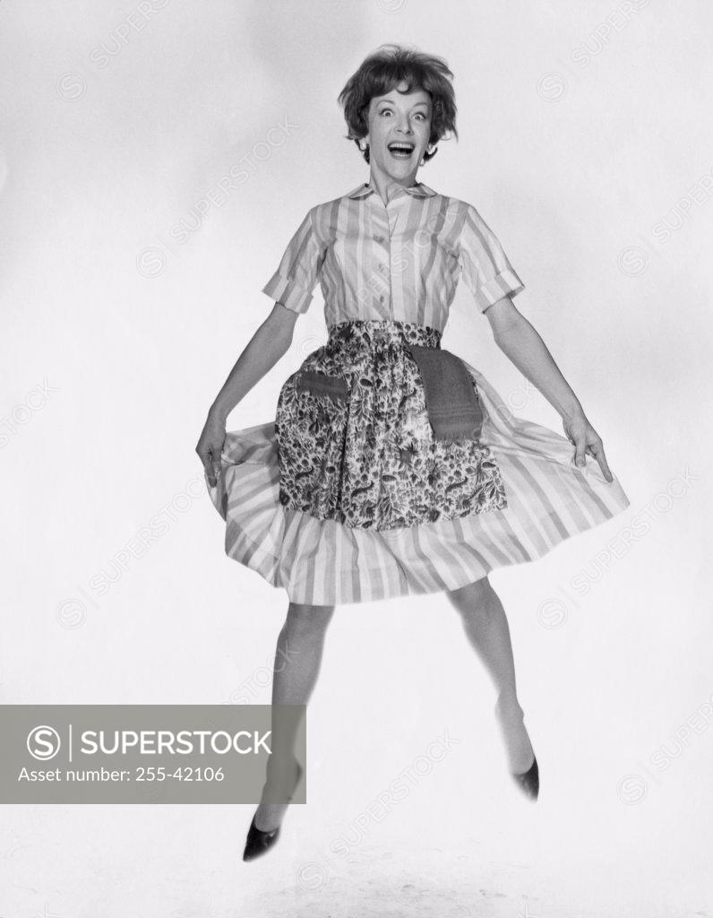 Stock Photo: 255-42106 Portrait of young woman laughing and jumping