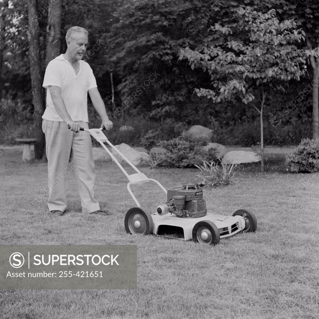 Stock Photo: 255-421651 Mature man lawn mowing