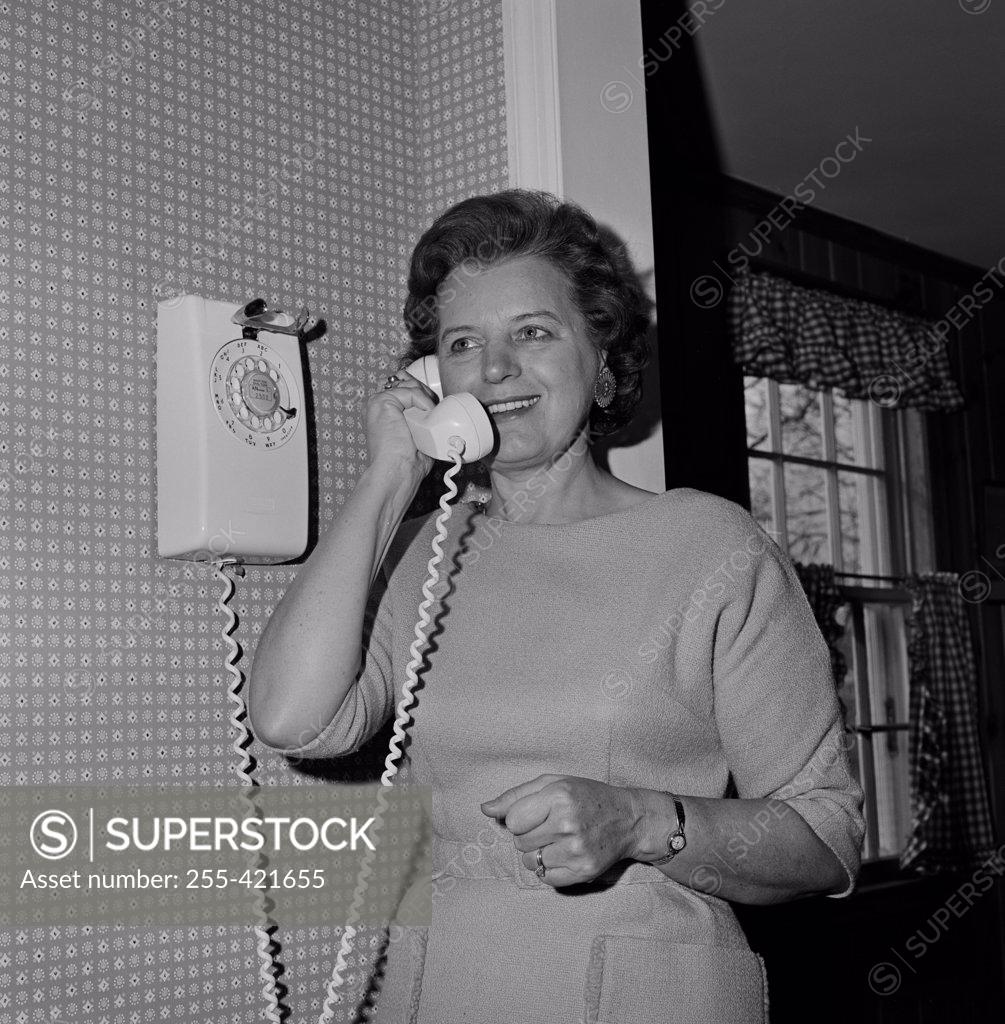 Stock Photo: 255-421655 Mature woman talking through phone and smiling