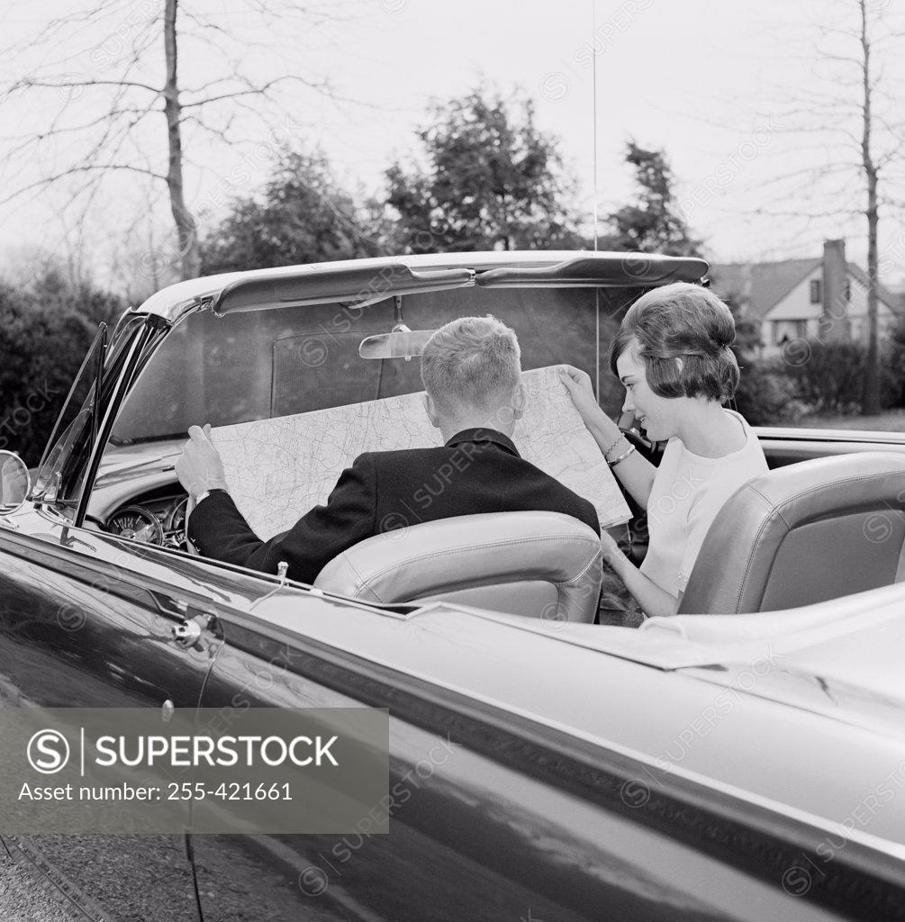 Stock Photo: 255-421661 Young couple in convertible car reading map