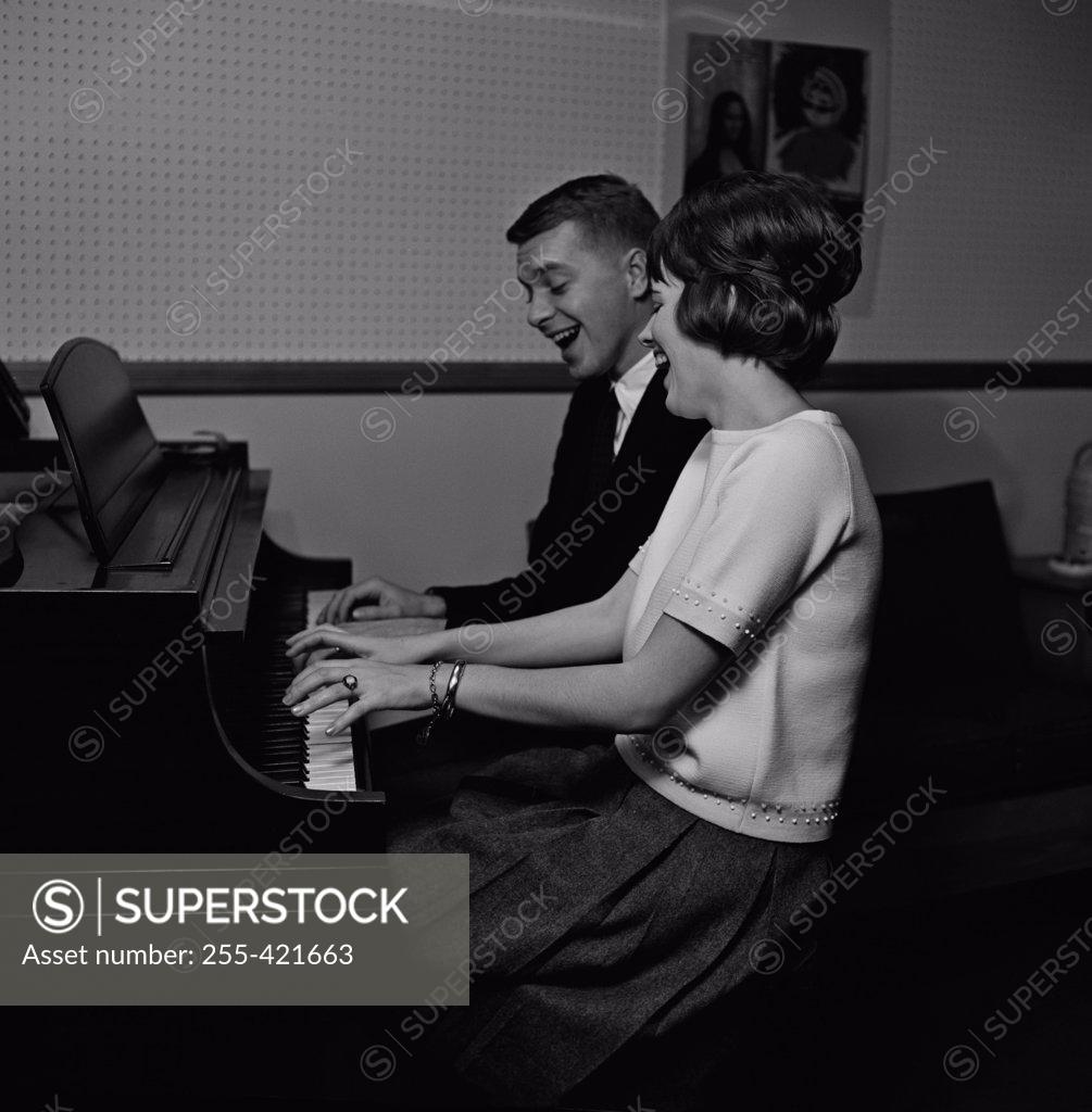 Stock Photo: 255-421663 Young couple playing piano and singing