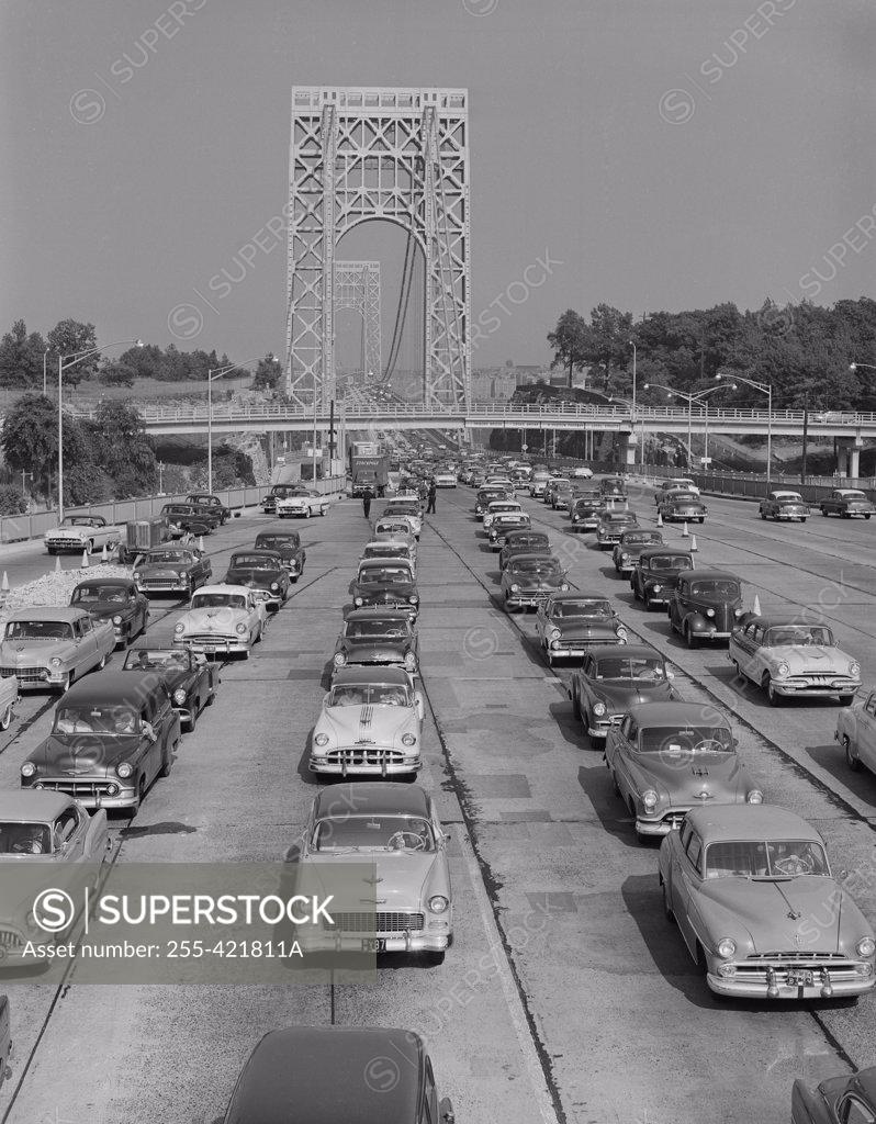Stock Photo: 255-421811A Cars on urban motorway with suspension bridge in background