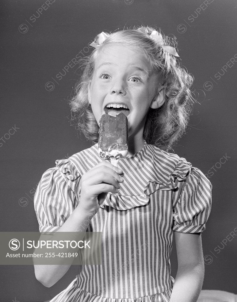 Stock Photo: 255-421849 Studio portrait of girl eating popsicle