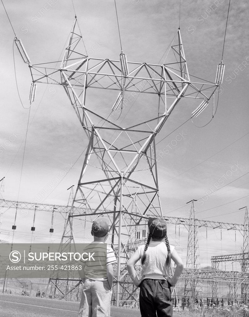 Stock Photo: 255-421863 Boy and girl looking at electricity pylon