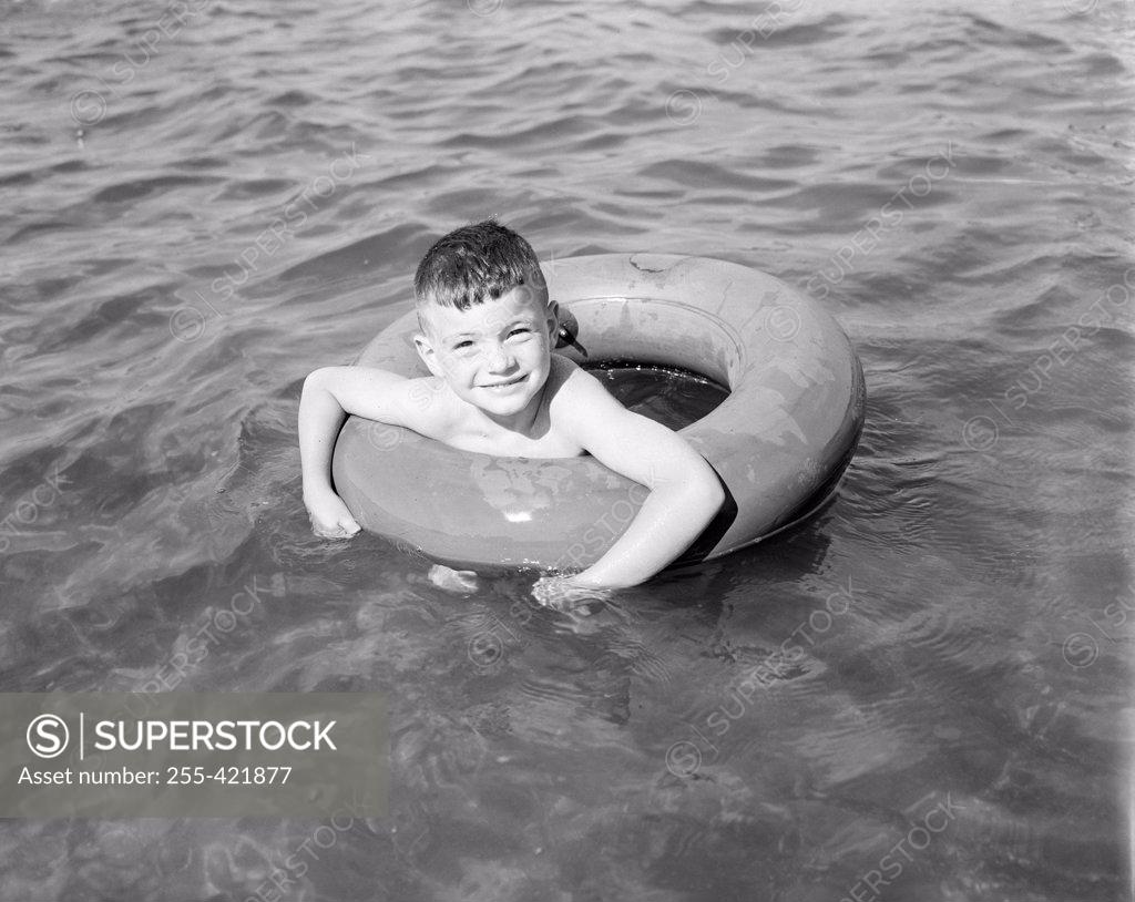 Stock Photo: 255-421877 Boy swimming in inflatable ring