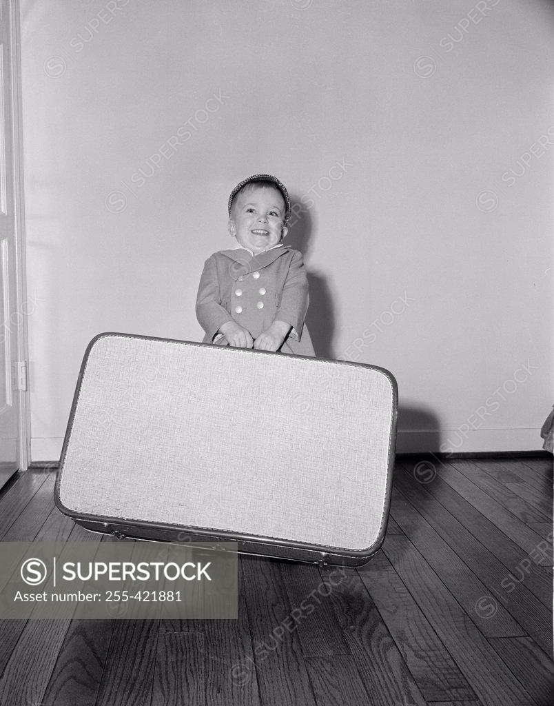 Stock Photo: 255-421881 Boy holding large suitcase