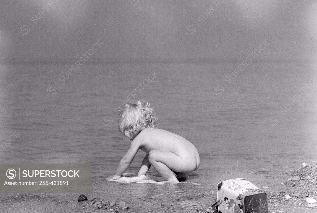 Stock Photo: 255-421891 Girl playing on lake shore