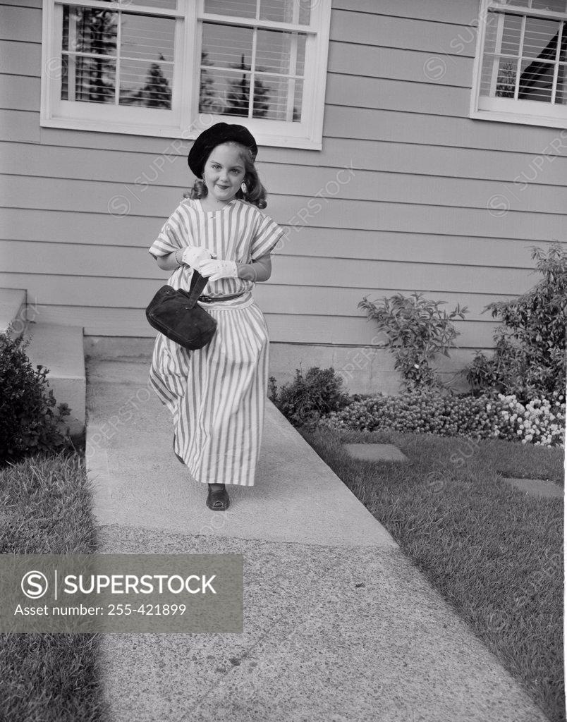 Stock Photo: 255-421899 Girl in evening wear walking down backyard path