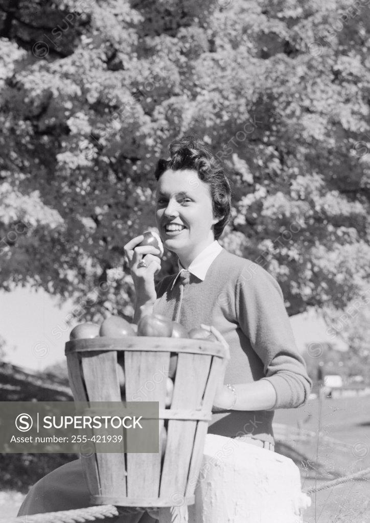 Stock Photo: 255-421939 Young woman with bucket of apples