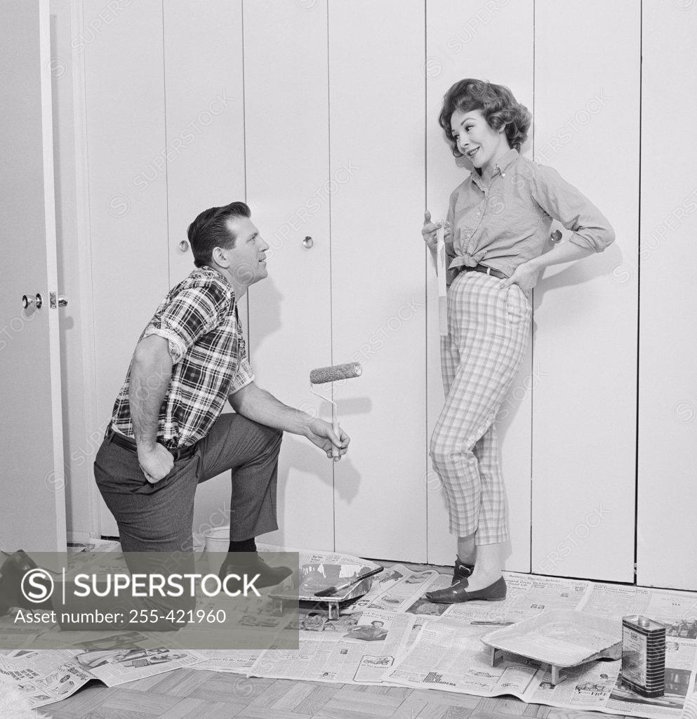 Stock Photo: 255-421960 House husband painting closet door while housewife is watching