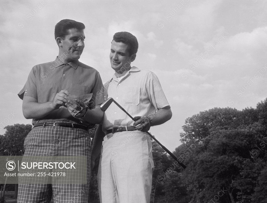 Stock Photo: 255-421978 Pair of male golfers checking score