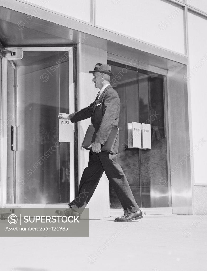 Stock Photo: 255-421985 Senior businessman entering office building